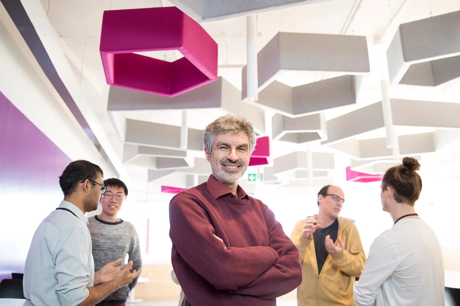 Portrait of AI researcher Yoshua Bengio smiling in a modern indoor setting, 2019