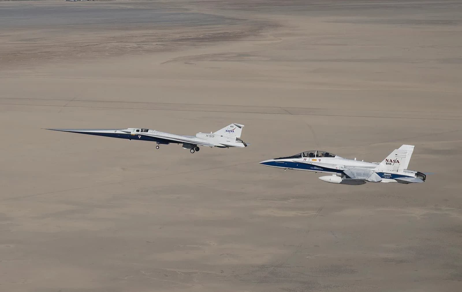 NASA's long-nosed X-59 aircraft in flight with an F-15 research jet alongside