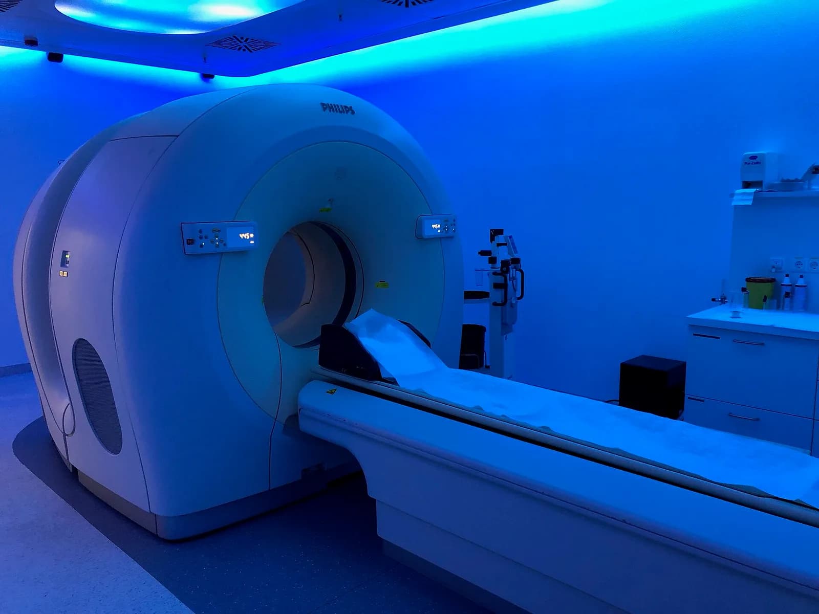 A conventional PET-CT scanner with its patient table in a hospital imaging room