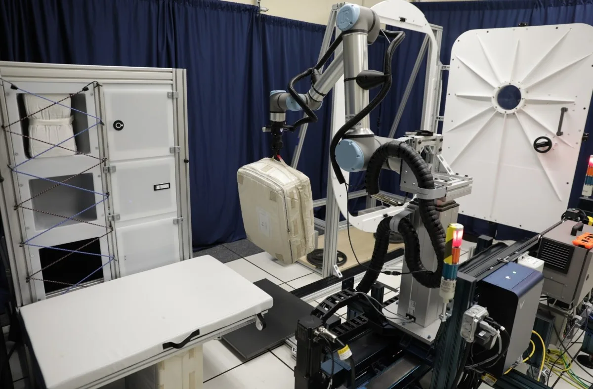NASA iMETRO robotic arm handling a cargo bag in a habitat test setting.